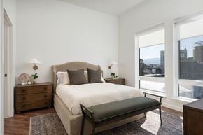 Boise apartment for rent - A bedroom with a large bed and a view of the city.
