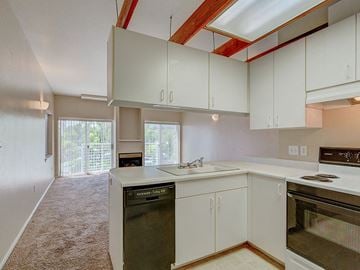 Boise apartment for rent - A kitchen with white cabinets and a black dishwasher.