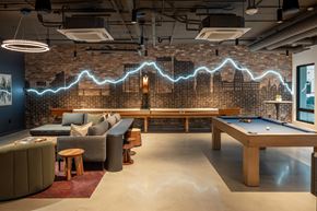 Boise apartment for rent - A room with a pool table and a brick wall with a lightning bolt design.