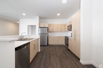 A kitchen with wooden floors and white walls.