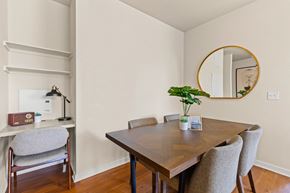 Denver apartment for rent - Chic seperate dining room with a patterned wood table next to a small built-in desk with wall shelving and a grey chair at Sylvan Uptown, Denver, CO