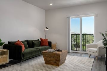 Garden City apartment for rent - a living room with a green couch and a large window