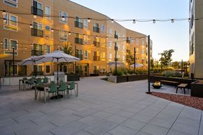 Garden City apartment for rent - a courtyard with tables and umbrellas in front of an apartment building at Crosshatch, Garden City, ID, 83714