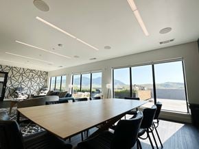Bozeman apartment for rent - A conference room with a long table and chairs, a patterned wall, and a view of the mountains outside the windows at Cannery Flats, Bozeman, Montana