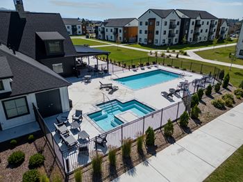 A swimming pool surrounded by a black fence and a grassy area.