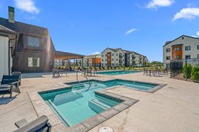 Kalispell apartment for rent - Soothing spa with view of the pool surrounded by pool chairs and tables at Silverbrook Apartments, Kalispell, 59901