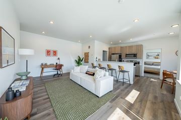 Kalispell apartment for rent - A living room with a white couch and a green rug.
