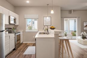 Nampa townhouse for rent - an open kitchen and dining area with a white counter top and a stainless steel refrigerator at Southside Townhomes, Idaho, 83686