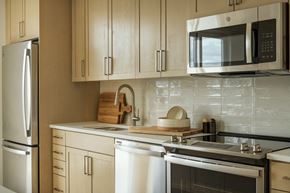 Boise apartment for rent - a kitchen with white cabinets and a sink and a microwave