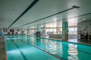 Boise apartment for rent - a swimming pool in a gym with a blue water at The Lucy Boise Apartments, Boise