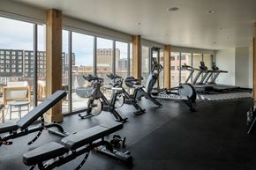 Boise apartment for rent - a gym with exercise bikes and a view of the city