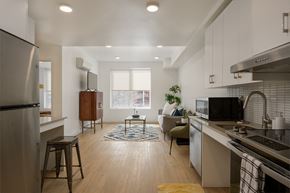 Boise apartment for rent - an open kitchen and living room with a large window and a refrigerator at The Lucy Boise Apartments, Boise