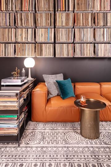 Minneapolis apartment for rent - A living room with a leather couch, a table with a candle, and a wall of records.