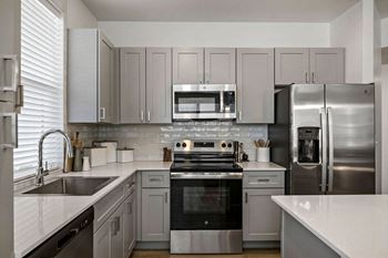 A kitchen with stainless steel appliances and white cabinets