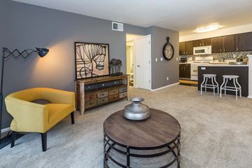 Colorado Springs apartment for rent - A yellow chair sits in a living room with a coffee table in front of it.