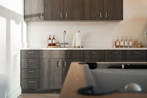 Garden City apartment for rent - A kitchen with dark wood cabinets and a white backsplash.at Copestone Apartments, Garden City
