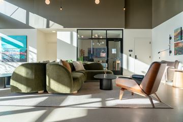 Boise apartment for rent - A modern living room with a green sofa and a wooden chair.