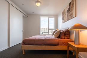 Boise apartment for rent - A bedroom with a bed, nightstand, and window.