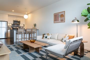 Boise apartment for rent - A modern living room with a white couch and a wooden coffee table.