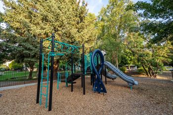 Community playground with colorful equipment and wood chips