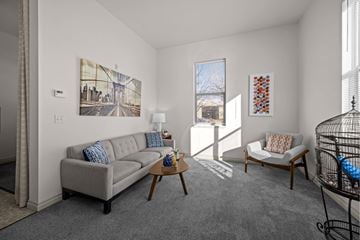 Missoula apartment for rent - A living room with a grey couch and a painting on the wall.