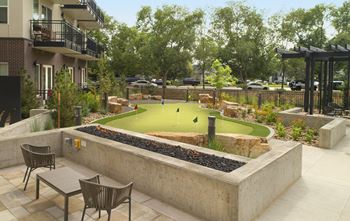 A courtyard with a miniature golf course and tables and chairs