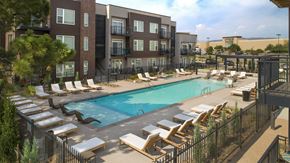 Fort Collins apartment for rent - a swimming pool with lounge chairs in front of an apartment building at Cycle Apartments, Fort Collins, CO