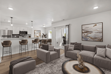 Nampa apartment for rent - A modern living room with a grey sofa, a coffee table, and a kitchen area in the background.