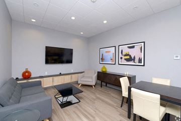 Cambridge apartment for rent - A living room with a grey couch, a black coffee table, and a television mounted on the wall.