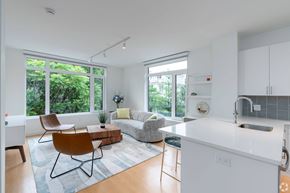 Cambridge apartment for rent - A modern kitchen with white cabinets and a white island with quartz countertops at 605 Concord at Fresh Pond, Cambridge, 02138