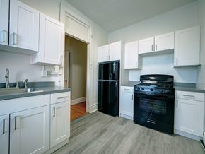 Troy apartment for rent - A kitchen with black appliances and white cabinets.