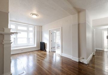 Troy apartment for rent - an empty living room with wood floors and a window