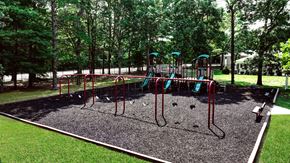 Coram apartment for rent - A playground with a red swing set and a green slide.