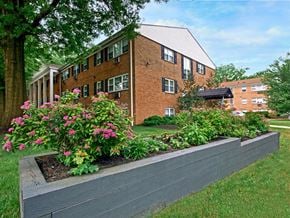 Rahway apartment for rent - A brick building with a flower bed in front of it.
