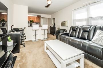 Garwood apartment for rent - A black leather couch sits in a living room with a white coffee table in front of it.