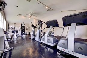 Cohoes apartment for rent - a gym with cardio machines and a ceiling fan
