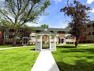 Menands apartment for rent - A small white gazebo is in the middle of a grassy area in front of apartment buildings.