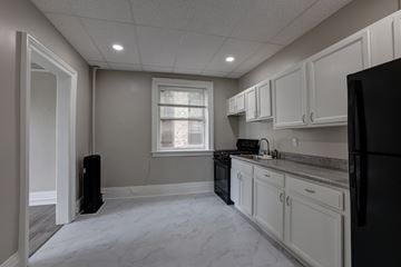 Albany apartment for rent - A kitchen with black appliances and white cabinets.
