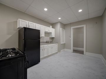 Albany apartment for rent - A kitchen with a black refrigerator and a black stove top.