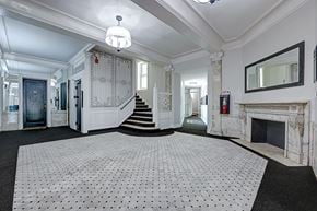 Albany apartment for rent - A large white tiled floor in a spacious room with a staircase and a fireplace.