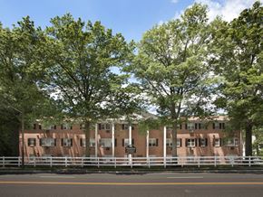 Rahway apartment for rent - A building with a white fence in front of it.