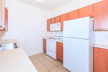 Glendale apartment for rent - A kitchen with white appliances and wooden cabinets.