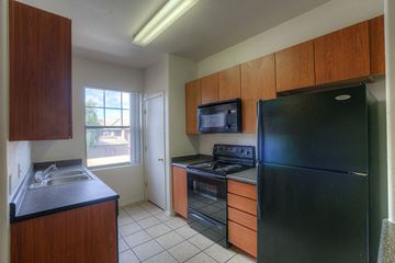 Gilbert apartment for rent - A kitchen with black appliances and wooden cabinets.