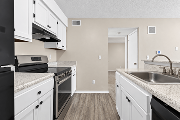 Kansas City apartment for rent - A kitchen with white cabinets and a black oven.