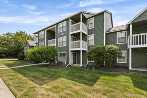 Kansas City apartment for rent - Apartment complex with green buildings and a clear sky.