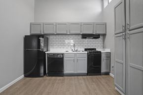 El Paso apartment for rent - a kitchen with white cabinets and black appliances and a black refrigerator
