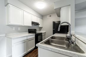 Las Cruces apartment for rent - an empty kitchen with white cabinets and a stainless steel sink