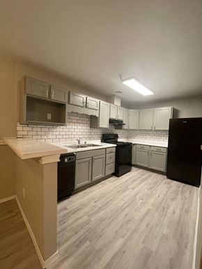 Las Cruces apartment for rent - an empty kitchen with white cabinets and black appliances