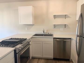 Anchorage apartment for rent - A kitchen with a stove, sink, and refrigerator.
