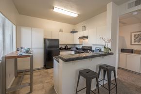 Roseville apartment for rent - A kitchen with a black refrigerator and white cabinets at Autumn Oaks Apartments, Roseville, CA, 95678